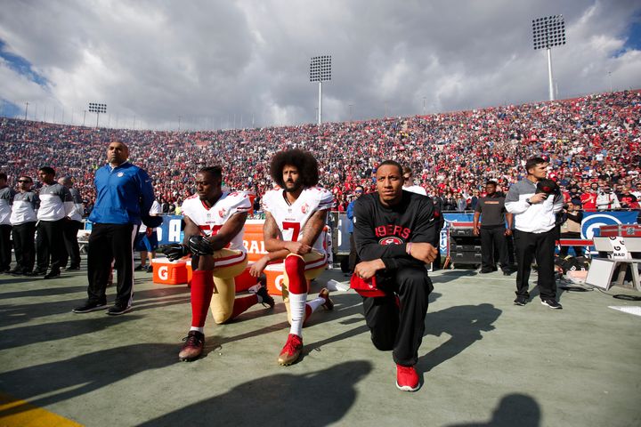 Eli Harold #58, Colin Kaepernick #7 and Eric Reid #35 of the San Francisco 49ers kneel on the sideline, during the anthem, prior to the game against the Los Angeles Rams at the Los Angeles Coliseum on December 24, 2016 in Los Angeles, California. 