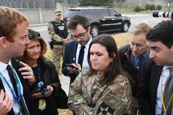 White House press secretary Sarah Huckabee Sanders (center) speaks to reporters after the helicopters returned from the