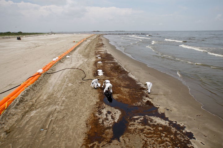 BP oil company contract workers remove oil that washed onto the beach at Grand Isle State Park in Louisiana on June 6, 2010.