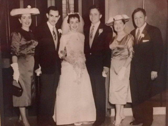 Bride Anita and Groom Pablo on their wedding day in 1957, posing with their parents. Anita wore a different wedding dress that was also made by her mother. 