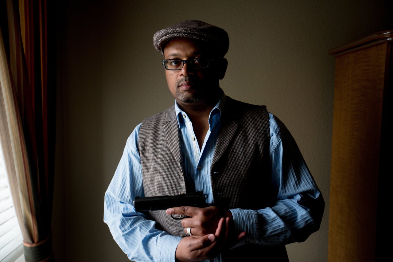 Rodney Jackson holds one of his guns at his home in Plano, Texas.