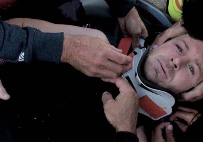 Pain shows in Andrew Cotton's eyes as he's strapped to a stretcher.