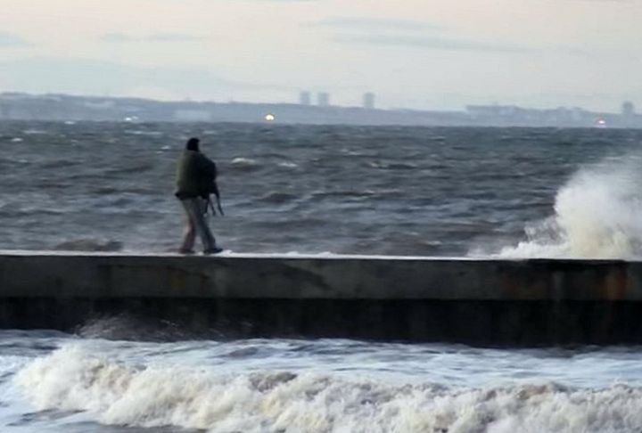 A man carries the dog to the end of the pier in Hartlepool, County Durham