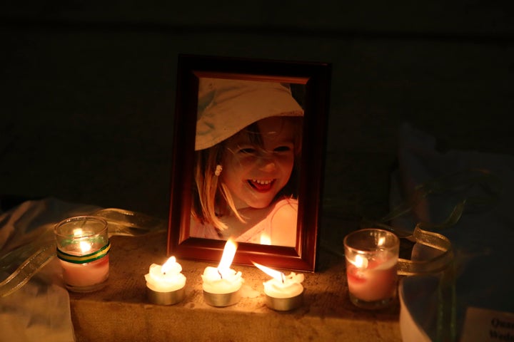 Candles light a photograph of Madeleine McCann inside the church of Praia da Luz, near Lagos, on May 3, 2017, during a mass c