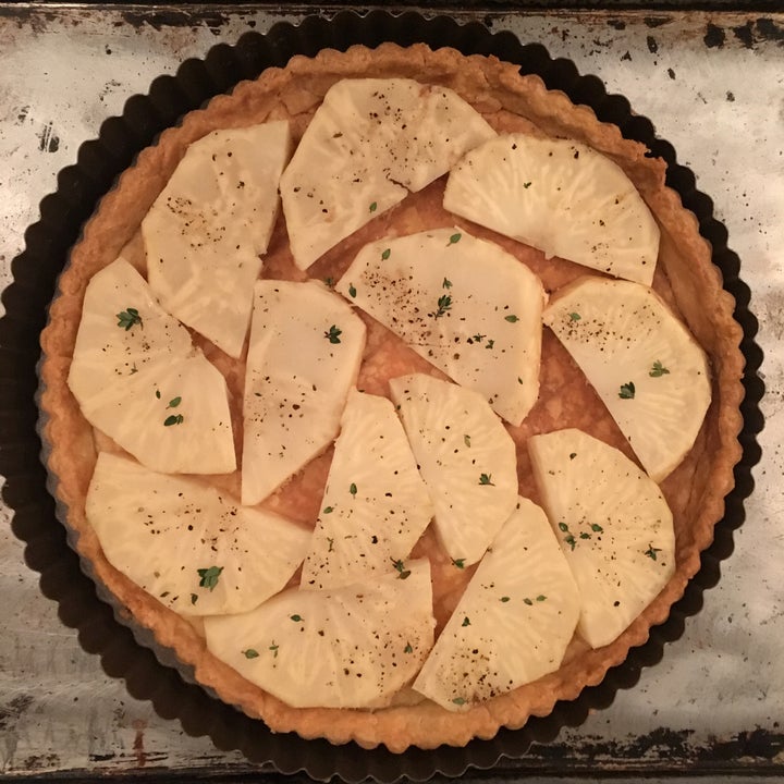 A layer of cooked celery root slices, well seasoned