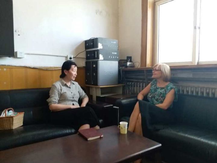 Dr. Zheng Hong and Kelly Davenport talking in an office at Dandelion School.