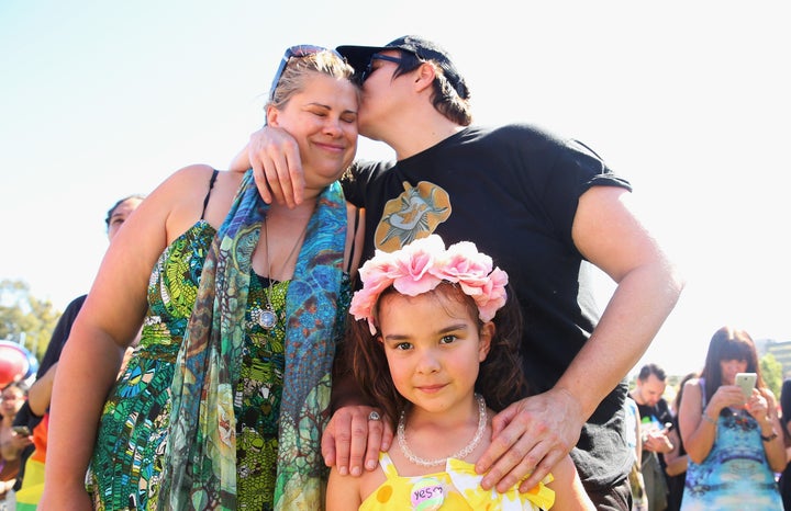 Mathilda Bowman, 5, looks on as her mothers, Kate Bowman and Melinda Voigt, each place a hand on her shoulder in Sydney.