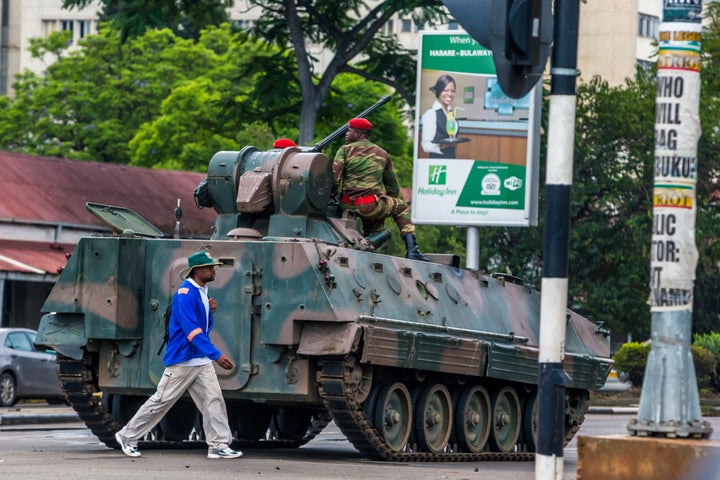 A man walks past a tank stationed at an intersection in Harare as Zimbabwean soldiers regulate traffic on Nov. 15, 2017.