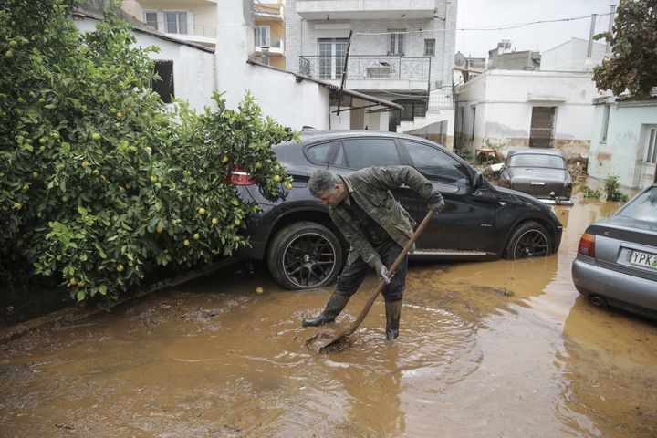 A man tries to remove floodwater from the area after torrential rains.