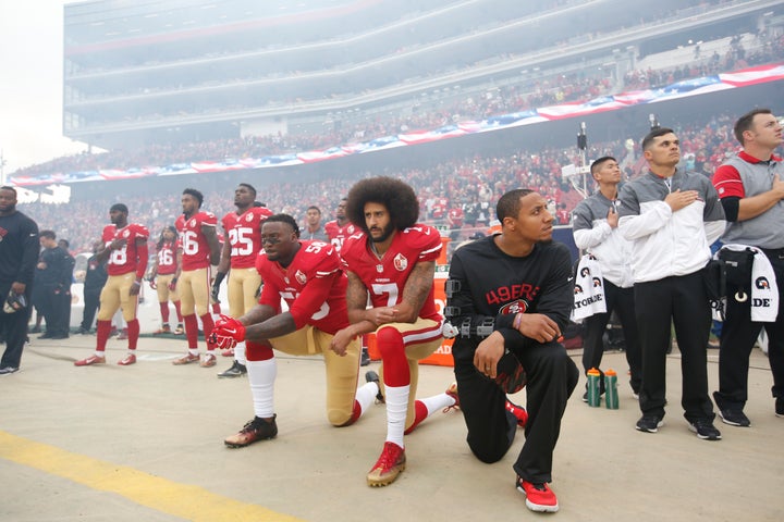 From left to right, Eli Harold, Colin Kaepernick and Eric Reid of the San Francisco 49ers kneel during the national anthem on