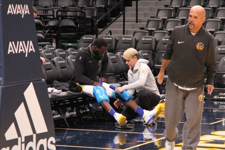 Reigning Defensive Player of the Year Draymond Green has his knees wrapped with ice following the Warriors’ morning shoot around. Applying the ice is Chelsea Lane, the team’s head of physical performance and sports medicine, and in the foreground is the team’s legendary Vice President of Communications, Raymond Ridder.