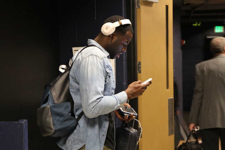 Draymond Green looks at his phone at he walks through the team tunnel at the Pepsi Center prior to the start of the game.