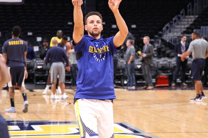 Stephen Curry practices a half court shot during pregame warmups.