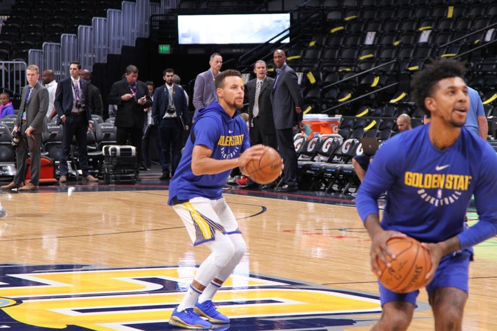 Stephen Curry gets ready to launch a half court shot during pregame warmups. Newly acquired Golden State Warriors guard Nick Young is in the foreground.