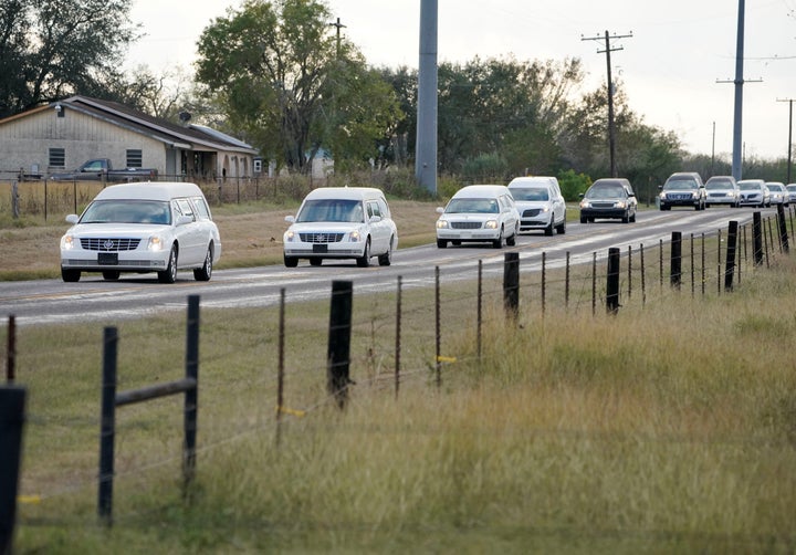 Hearses carry the bodies of six members of the Holcombe family and three members of the Hill family to a graveside service in