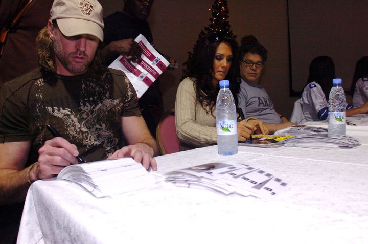 From left to right, musician Darryl Worley, sportscaster Leeann Tweeden and comedian Al Franken greet soldiers during an autograph session in Kuwait, Dec. 14, 2006.