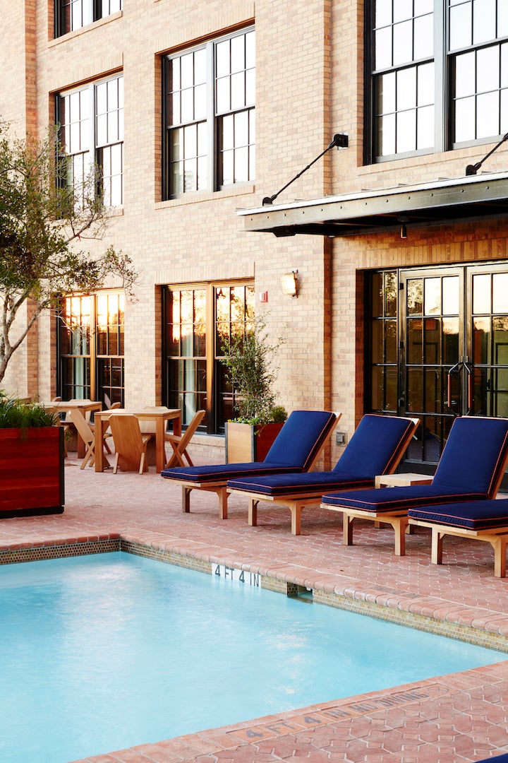 <p>One of the courtyards includes a pool, built to fit in seamlessly with the hotel’s design and featuring upholstered seating in shades of navy blue. </p>
