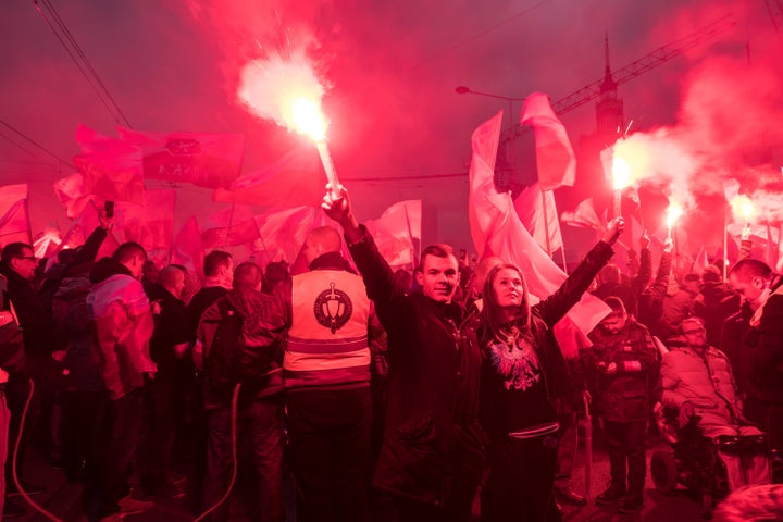 A couple holds flares as thousands gather for the annual march for Poland's Independence Day. The annual event marks the rest
