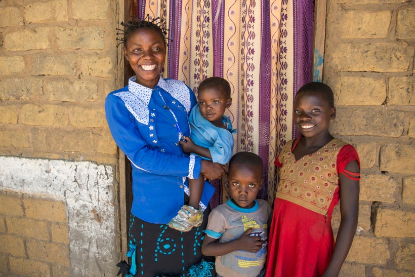 Joelle Inamulongo with her children at their home in the village of Katchambuyu, DRC. She is a beneficiary of the WASH projec