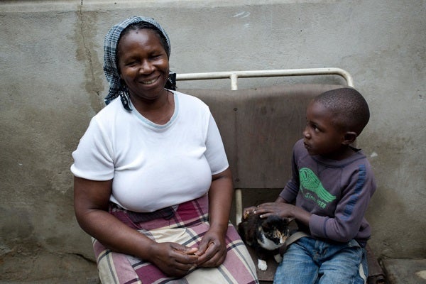 <em>(Left) Sophia Pedro Kumbana sits with her grandson Edmar Joseph, as he pets a kitten, outside her home in Maputo, Mozamb