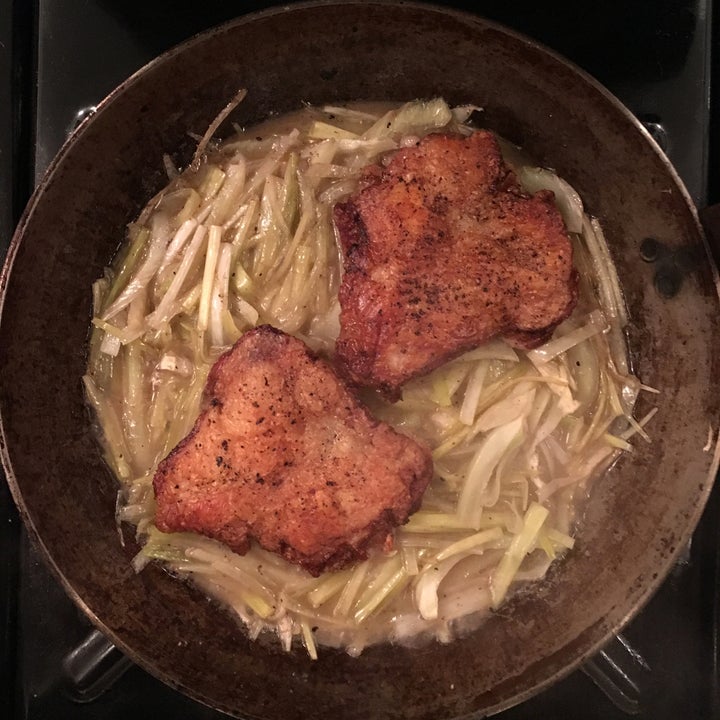 <p>The chicken continues cooking skin side up on a bed of leeks, fennel and chicken stock</p>