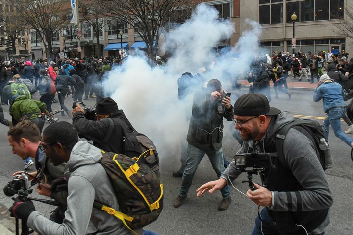 Protesters and journalists scramble as stun grenades are deployed by police during the demonstrations on Jan. 20.