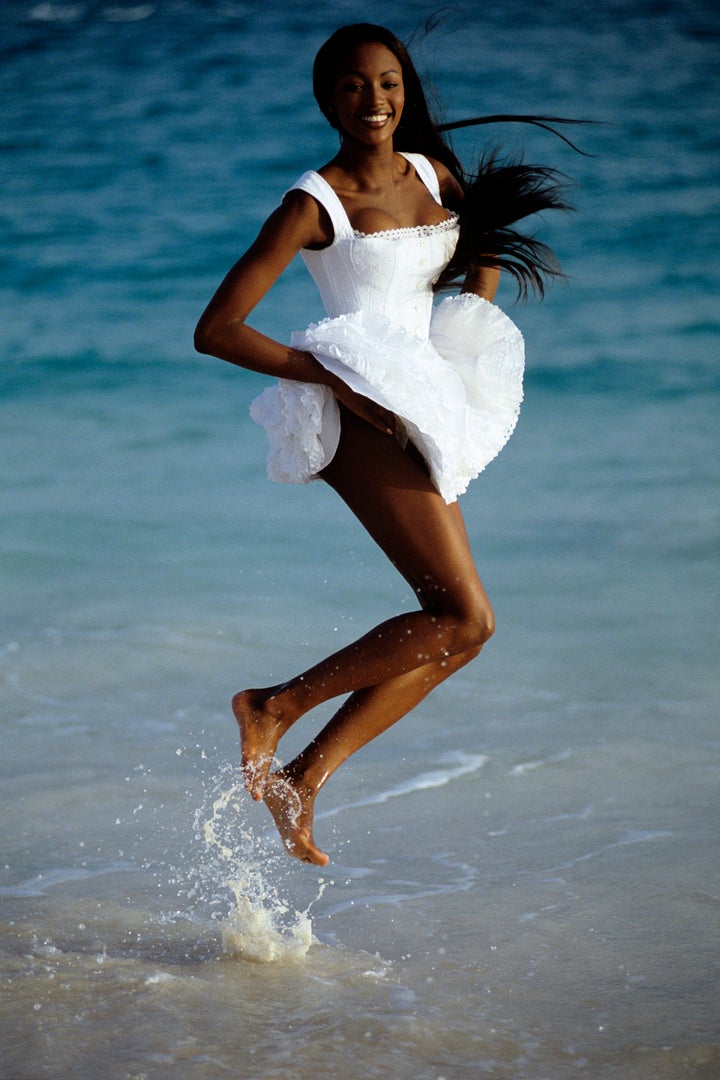 Naomi Campbell wearing a white Azzedine Alaïa dress.