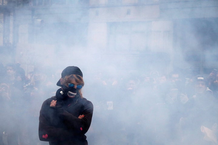 An activist stands amid smoke from a stun grenade while protesting in Washington, D.C., Jan. 20, 2017.