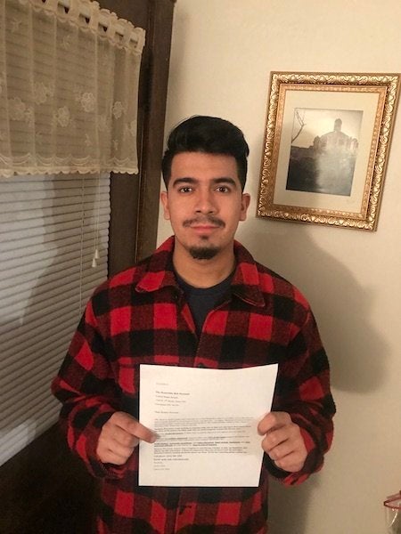 Ariel Lopez stands with a letter addressed to Senator Rob Portman requesting clarity on his DACA stance as well as his views