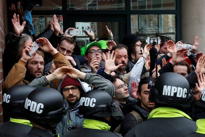 Protesters demonstrating against Trump raise their hands as they are surrounded by police on the sidelines of the inauguration in Washington, Jan. 20, 2017.