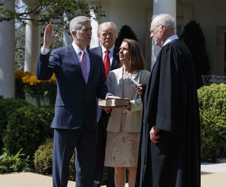 President Trump observes as Associate Justice Neil Gorsuch (left), flanked by his wife, is sworn in by Associate Justice Anthony Kennedy (right).