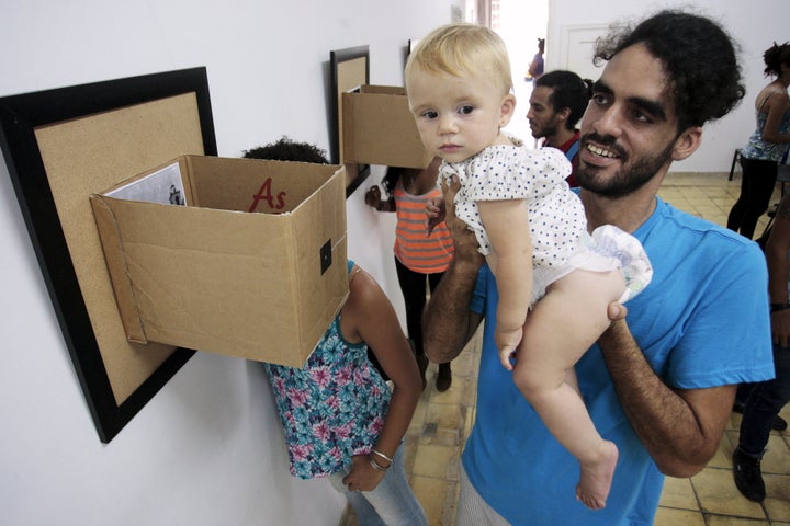 Cuban artist Danilo Maldonado Machado poses with his daugther during a photo exhibition in Havana