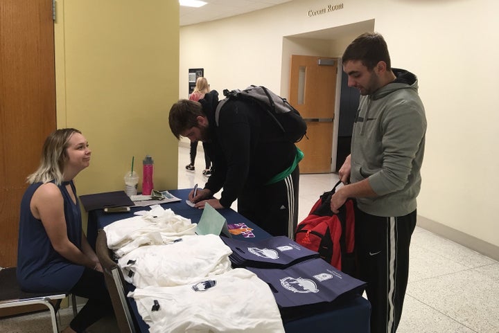 Mount St. Joseph University student Monica Brucher looks on as students donate to a “silent guest” fundraiser for the World Food Program in South Sudan. The Mount’s fundraising page is here. 