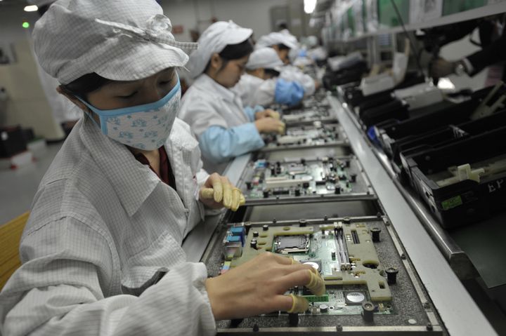Chinese workers are seen at a Foxconn factory in Shenzhen in 2010. The contractor for Apple products has admitted that some students worked excessive hours.