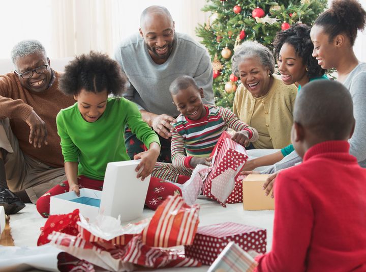 Family opening Christmas presents together KidStock via Getty Images