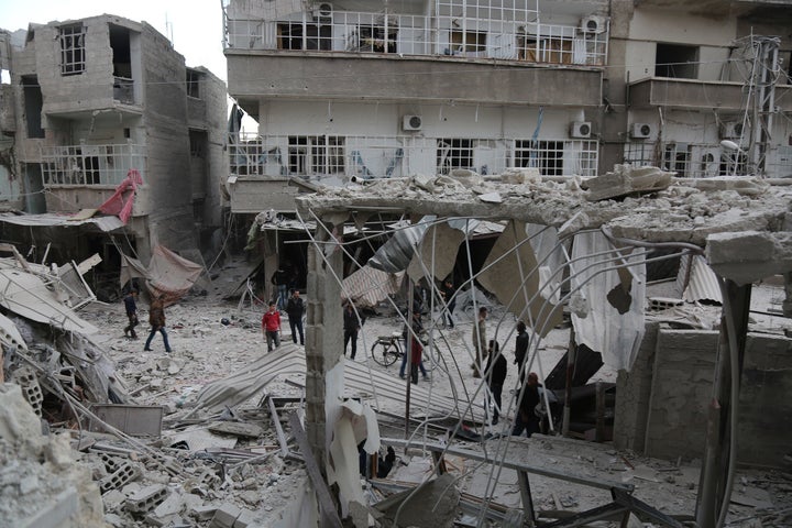 Syrians in eastern Ghouta inspect the damage after an airstrike reportedly carried out by the Assad regime on Monday.