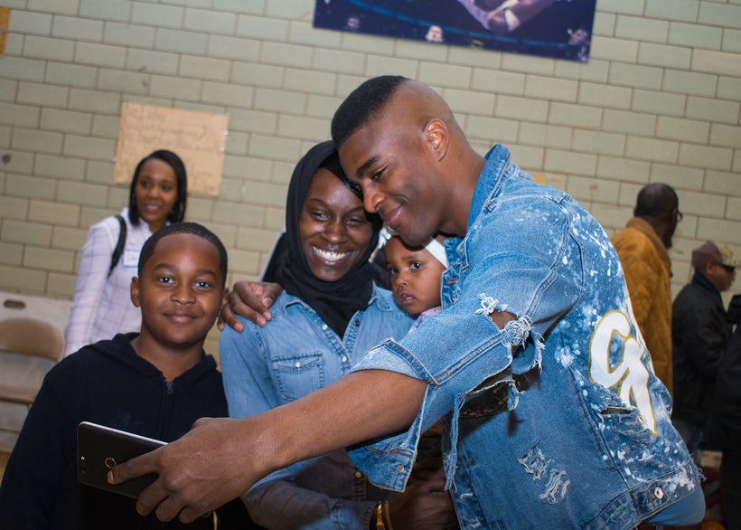 BMe Genius Nehemiah Davis takes a “ussie” with event attendees at the annual Food From Heaven Thanksgiving event.