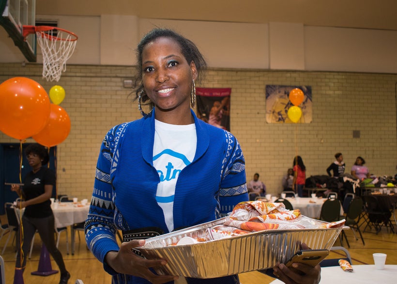 Circle of Greatness member Shante Williams hands out utensils at the annual Food From Heaven Thanksgiving event.