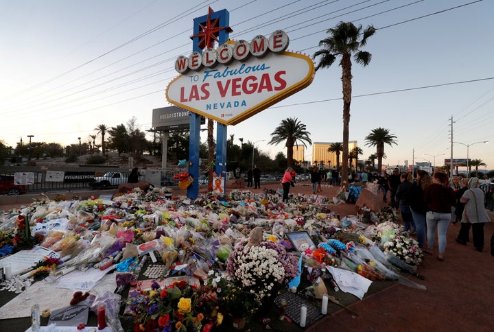 Flowers and other tributes to the victims of the Las Vegas massacre pile up at the iconic "Welcome to Las Vegas" sign.