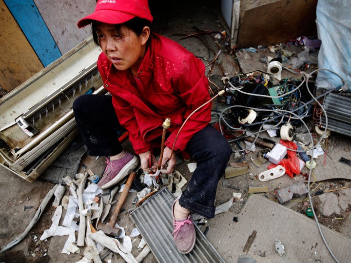 A woman dismantles e-waste for scrap at Dongxiaokou village in Beijing, a major center for recycling old electrical and electronic goods.