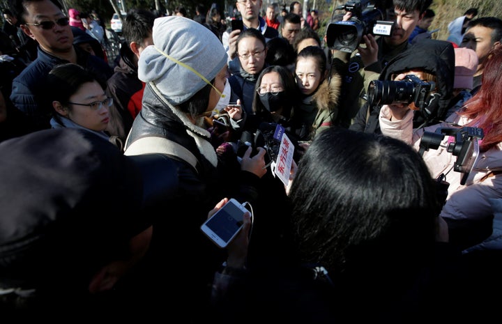 A parent is surrounded by the media outside RYB New World Kindergarten in Beijing on Nov. 24, 2017.