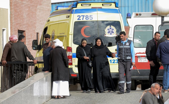 Relatives of the victims of the bomb and gun assault on the North Sinai Rawda mosque walk past an ambulance while waiting out