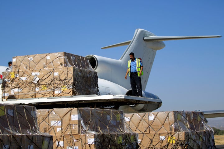 A technician unloads doses of vaccines from a plane after it landed in the rebel-held Yemeni capital Sanaa on November 25, 20