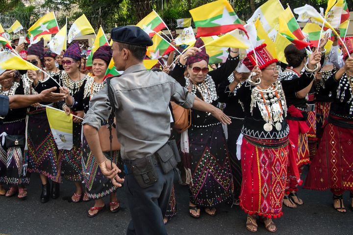 Ethnic Kachin people in traditional dress wait along a street in Yangon on November 27, 2017, in hope of catching a glimpse of Pope Francis after his arrival at the airport.