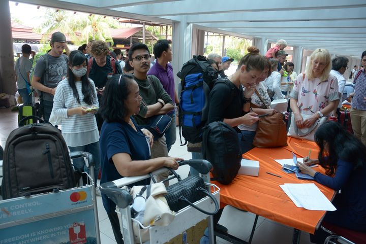Tourists try to obtain flight information following the closure of Ngurah Rai airport due to the eruption of Mount Agung
