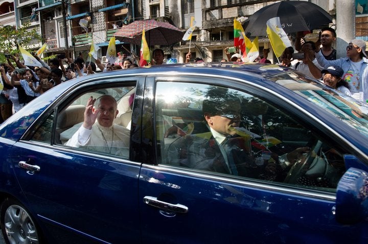 Pop Francis waving from a vehicle in downtown Yangon on Monday.