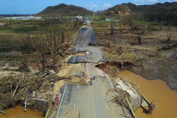 A man rides his bike through a damaged road in Puerto Rico on Sept. 24. 