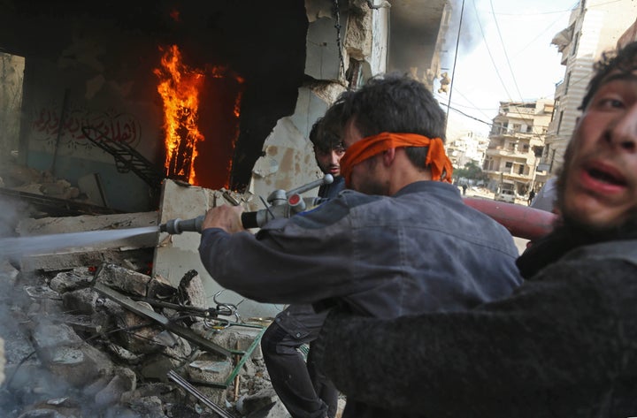 Members of The White Helmets try to extinguish flames after an air raid on the rebel-held town of Harasta, Syria.