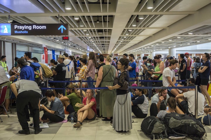 Passengers wait in line at the ticketing counter at Ngurah Rai International Airport near Denpasar, Bali, on Tuesday. Th