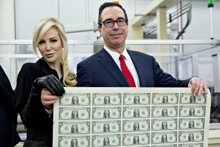 U.S. Treasury Secretary Steve Mnuchin poses with his wife, Louise Linton, while holding an uncut sheet of $1 dollar notes bea